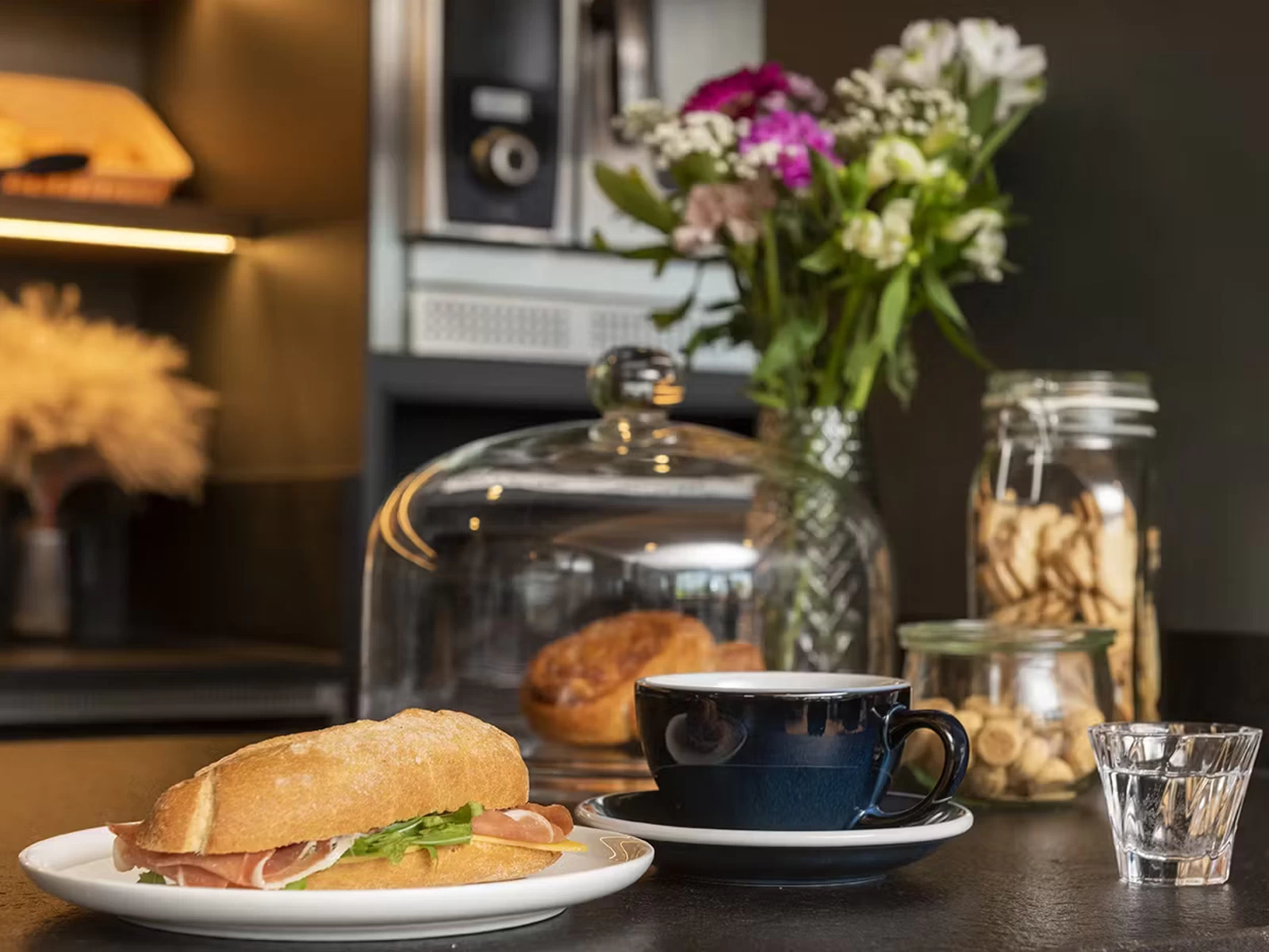 Frühstücksangebot im WaveCafé des Waveboard Hotels Potsdam mit frischem belegtem Brötchen, Kaffee und Gebäck in gemütlichem Ambiente. Perfekter Start in den Tag für Hotelgäste.