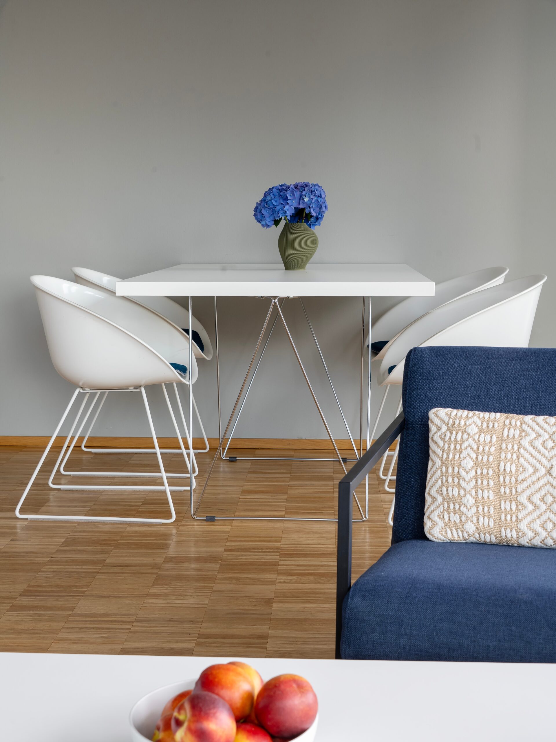 Moderner Essbereich im Wavehotel Potsdam mit weißem Tisch, Designerstühlen und Blumendekoration