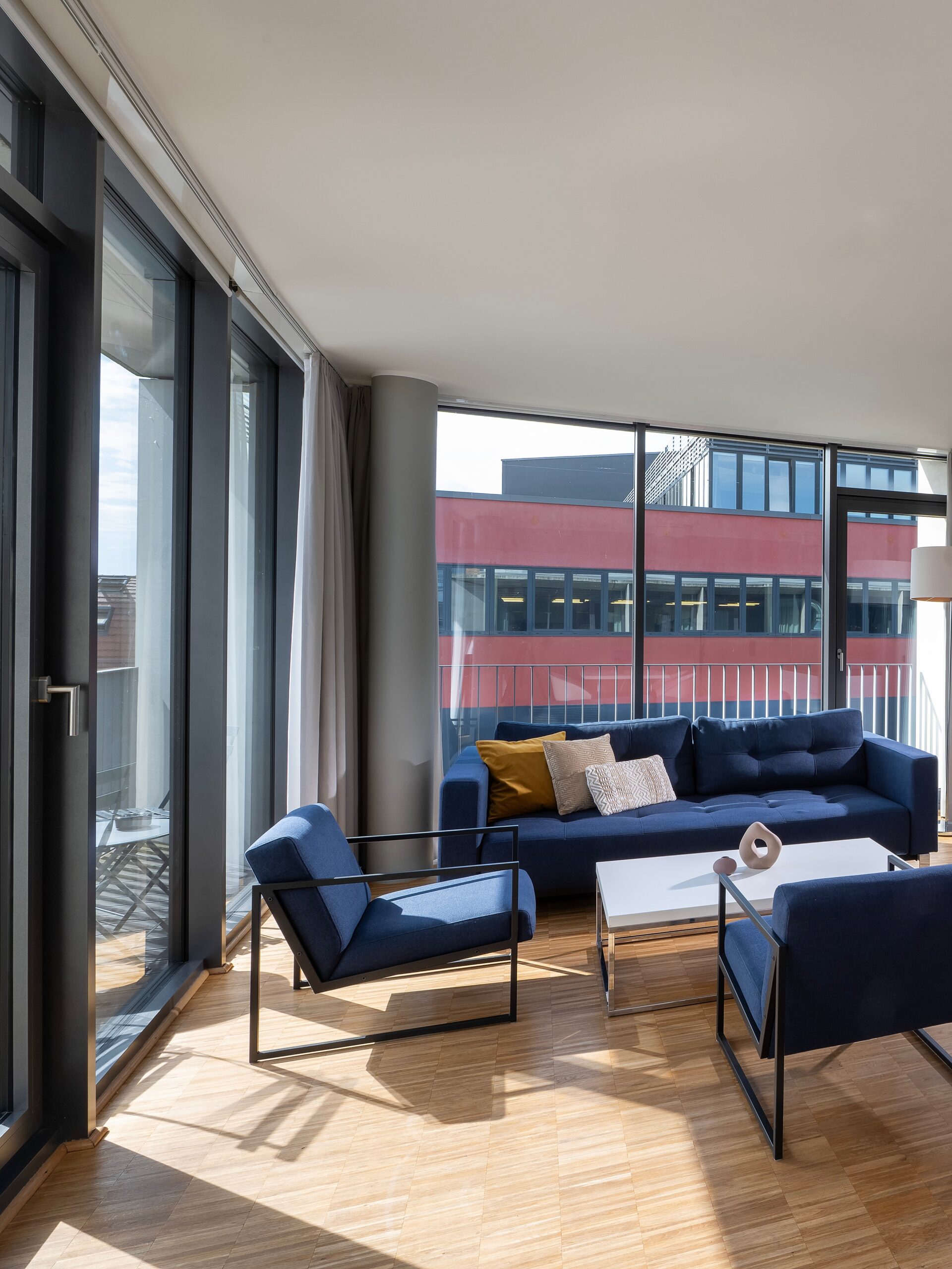 Helles Wohnzimmer mit großen Panoramafenstern und modernen Möbeln im Wavehotel Potsdam