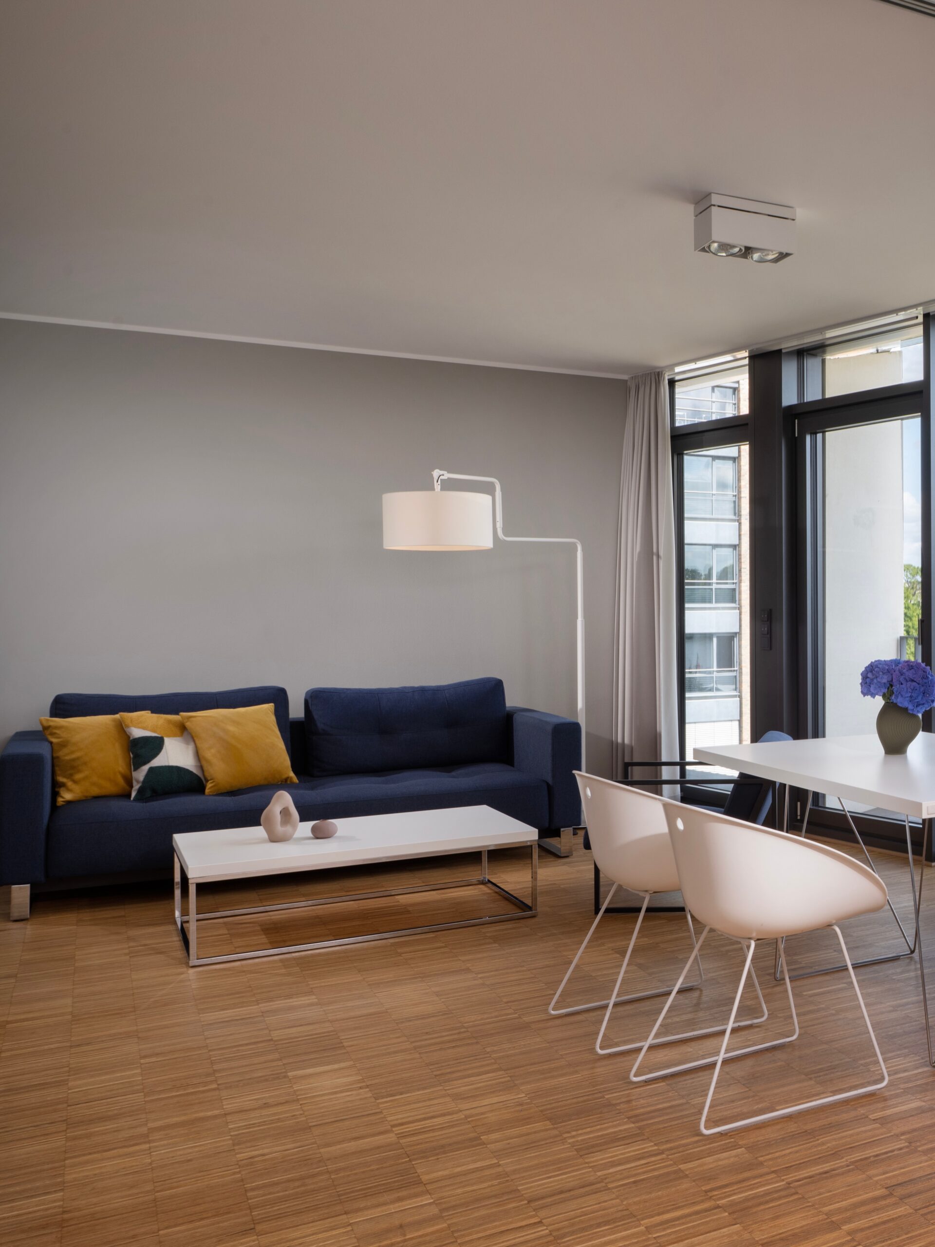 Apartment im Wavehotel Potsdam mit modernem Wohnbereich, Sofa, Couchtisch und Essplatz am Fenster